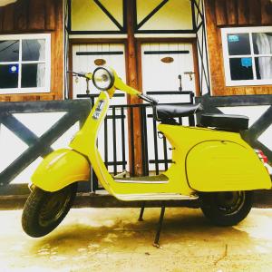 a yellow scooter parked in front of a building at The paulwood home cabin in Nuwara Eliya