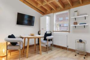 a dining room with a table and chairs and a tv at The Hoxton Loft - Top Floor Shoreditch Apartment in London
