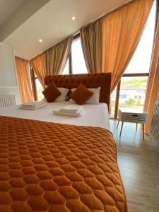 a bedroom with a large bed with a large window at Ami Residence Bucharest Airport&Therme&Parking in Otopeni
