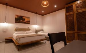 a bedroom with two beds and a table and a chair at Kronos Hotel in Durrës