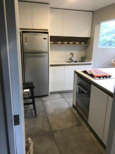 a kitchen with a stainless steel refrigerator and a table at Apartamento Full in Concón