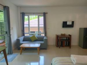 een woonkamer met een blauwe bank en een salontafel bij Phangan Akuna in Srithanu