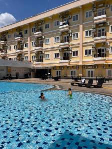 twee personen zwemmen in een zwembad in een hotel bij Apartemen MTC Unit 626 in Manado