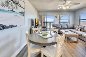 a living room with a table and a couch at Emerald Isle 204 in St. Pete Beach