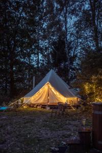 a large tent with chairs in a field at night at Glamping in - luxury tent 
