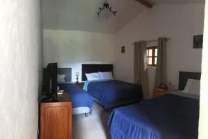een hotelkamer met 2 bedden en een televisie bij Santa Elena Hotel in Cajabamba