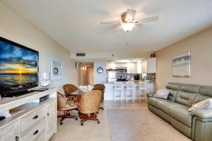 a living room with a couch and a flat screen tv at Emerald Isle 101 in St. Pete Beach