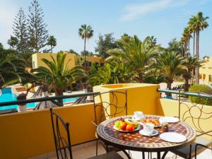 a table with a bowl of fruit on a balcony at Villa Rosa Fuerteventura in Corralejo