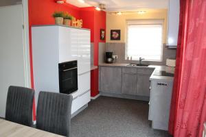 cocina con paredes rojas, mesa y sillas en Kustverhuur, Park Scheldeveste Zwin 031, en Breskens