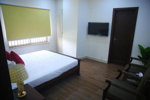 a bedroom with a bed and a flat screen tv at Gulberg Suites in Lahore
