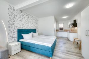 um quarto com uma cama azul e uma cozinha em Haus Diana - Zaunkönig em Waren