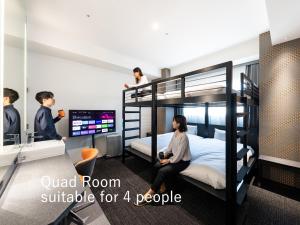 sequence SUIDOBASHI - Tokyo في طوكيو: مجموعة من الناس في غرفة مع سرير بطابقين