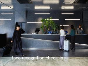 um grupo de pessoas esperando em um balcão de check-in de negociação de bagagem em sequence SUIDOBASHI - Tokyo em Tóquio