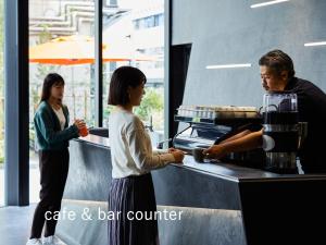 un hombre y una mujer parados en un mostrador de café y bar en sequence SUIDOBASHI - Tokyo, en Tokio