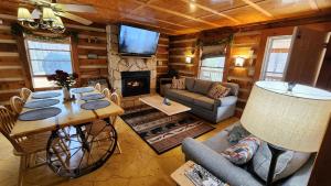 a living room with a table and a fireplace at Rustic Cabin in Sevierville