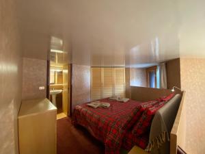 una camera con un letto con una coperta rossa di THE NEST Alpine Loft Ski-in Ski-out a Breuil-Cervinia