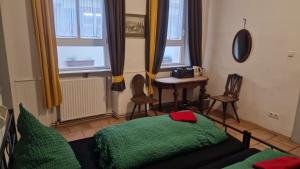 Pokój z łóżkiem, stołem i oknami w obiekcie Pension Jeske Heidelberg w mieście Heidelberg