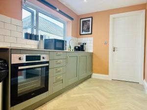 a kitchen with a stove top oven next to a window at MODERN ONE BEDROOM NEAR STATION SLP3 in Brighton & Hove