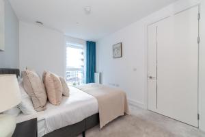 ein weißes Schlafzimmer mit einem Bett und einem Fenster in der Unterkunft The Woolwich Collection in Woolwich