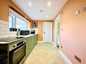 a kitchen with green cabinets and a window at MODERN ONE BEDROOM NEAR STATION SLP3 in Brighton & Hove