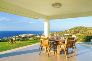 アギア・ペラギアにあるLux Villa Aspalathos with Pool, 700m to Beach, 1km to Restaurantの海の景色を望むパティオ(テーブル、椅子付)
