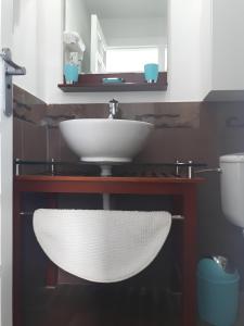 a bathroom with a white sink and a toilet at Agradable casa con entrada propia a la playa in Playa del Aguila