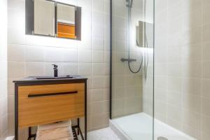y baño con ducha, lavabo y espejo. en NOUVEAU - Loft industriel - 4pp, en París