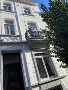 a white building with a balcony and a door at Rétro Studio in Brussels