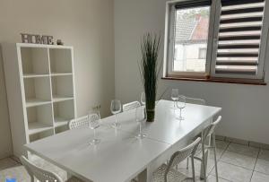 a white dining room table with wine glasses on it at Gohyssart 51b 2 Bruxelles-Charleroi-airport in Charleroi