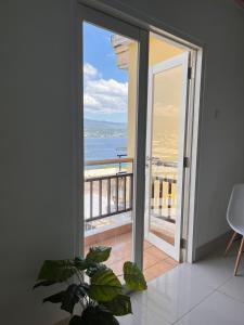 a room with a sliding glass door with a view of the ocean at Apartemen MTC Unit 626 in Manado