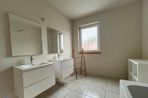 un bagno con due lavandini, uno specchio e una finestra di Gohyssart 51b 2 Bruxelles-Charleroi-airport a Charleroi