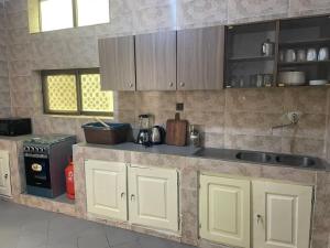 cocina con armarios blancos y encimera en Les Appartements Junior, en Cotonou