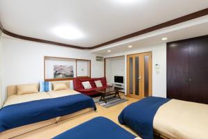 a bedroom with two beds and a living room at Shinjuku Yotsuya House in Tokyo
