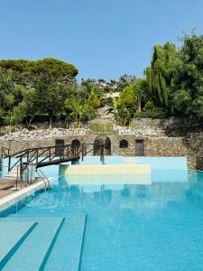 una grande piscina con ponte e acqua blu di Il Borgo Della Marinella ad Amantea
