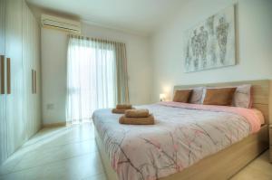 Modern 3BR Stylish & Spacious Apartment - Close to Sliema Promenade في إيل جزيرا: غرفة نوم بسرير كبير عليها منشفتين