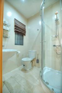 y baño con aseo, ducha y lavamanos. en Modern 3BR Stylish & Spacious Apartment - Close to Sliema Promenade, en Il-Gżira