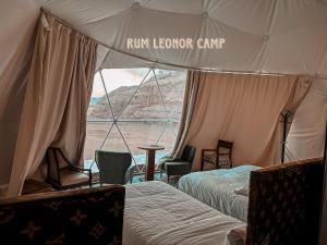 a tent with two beds and a table and chairs at RUM LEONOR CAMP in Wadi Rum