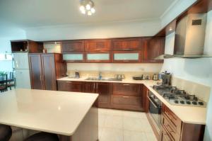 cocina con armarios de madera y encimera blanca en Modern 3BR Stylish & Spacious Apartment - Close to Sliema Promenade, en Il-Gżira