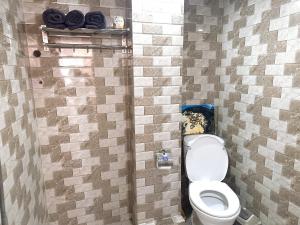 a bathroom with a toilet and a tiled wall at Kolor Home/2Brs/Near Hoankiem Lake/Old Quarter in Hanoi