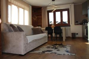 een woonkamer met een bank en een tafel bij 4Seasons appartamenti in Sauze dʼOulx