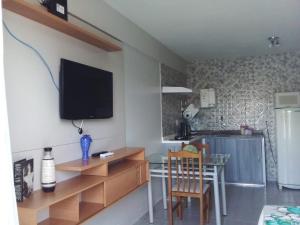 a living room with a table and a television on the wall at Apto 349 Terceira avenida Multishoping Centro Nucleo Bandeirante in Brasilia +24 photos