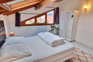 Schlafzimmer mit einem Bett mit weißer Bettwäsche und einem Fenster in der Unterkunft duplex cocooning à 10 min à pied du centre ville in Saint-Nabord