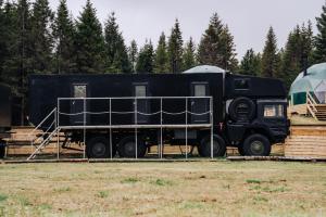 a black truck is parked in a field at Golden Circle Truck Experience in Selfoss
