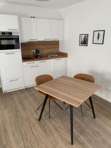 eine Küche mit einem Holztisch und Stühlen in der Unterkunft Businessapartment Metzingen Wilhelmstraße in Metzingen