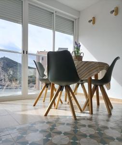 Apartamento, La Cala Vicent&Alba في كالا دي فينيسترات: غرفة طعام مع طاولة وكراسي مطلة