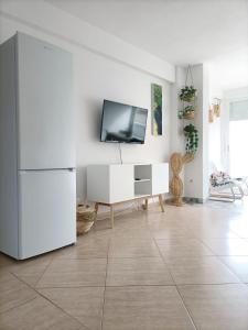 a living room with a tv and a white refrigerator at Apartamento, La Cala Vicent&Alba in Cala de Finestrat