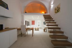 uma escada que leva a uma sala de jantar e cozinha com uma mesa em Old Stone House em Bari