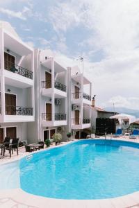 un hotel con piscina frente a un edificio en Abbey Resort, en Monastiraki