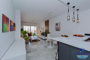 cocina y sala de estar con paredes y suelos blancos en Breakfast at Tiffanys en La Herradura