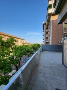 einen Balkon eines Gebäudes mit Bäumen und Gebäuden in der Unterkunft Big Terrace Modena Apartment in Modena